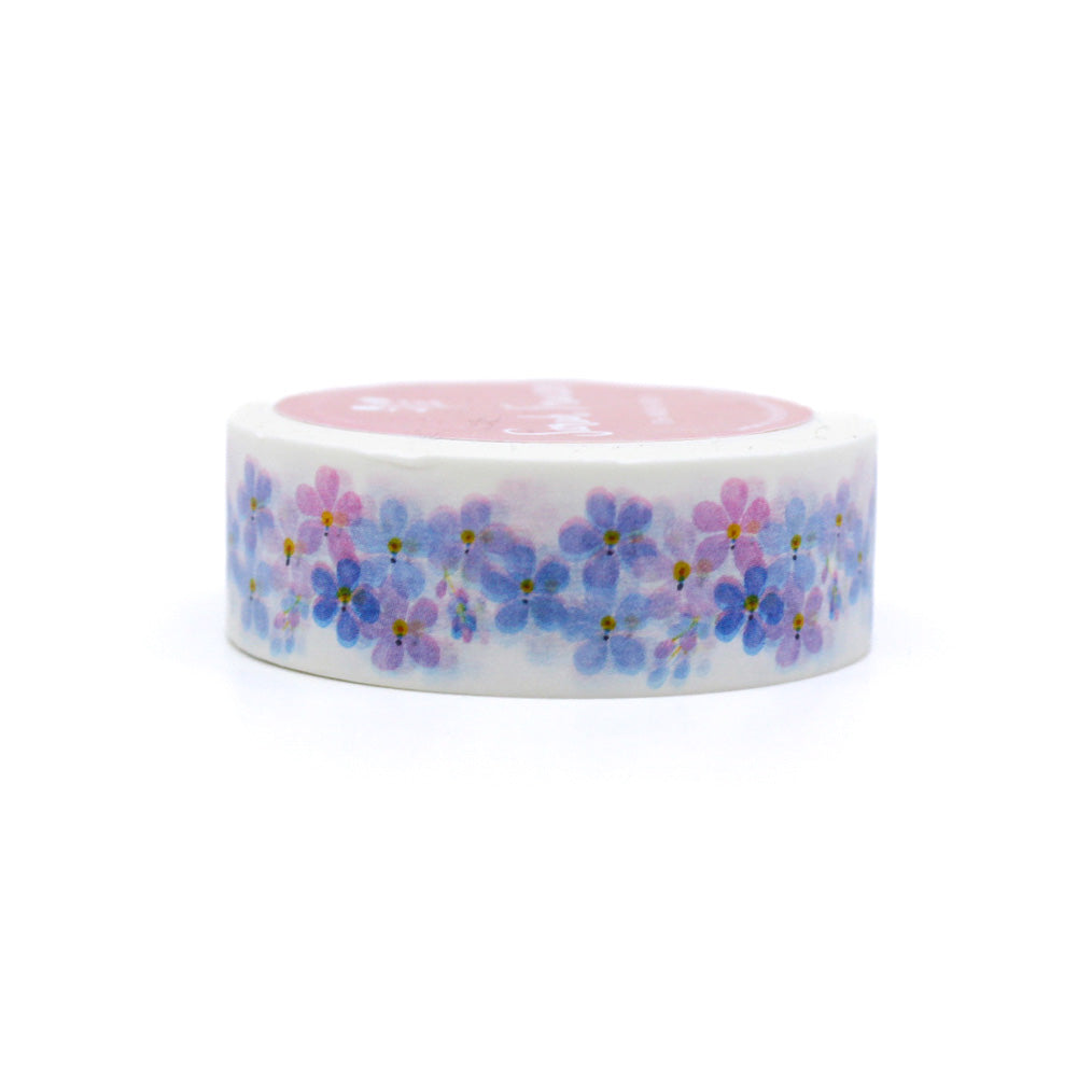 "Purple Forget-Me-Nots Floral Washi Tape" showcases a beautiful pattern of delicate purple forget-me-not flowers, perfect for adding a touch of floral elegance to your creative projects.