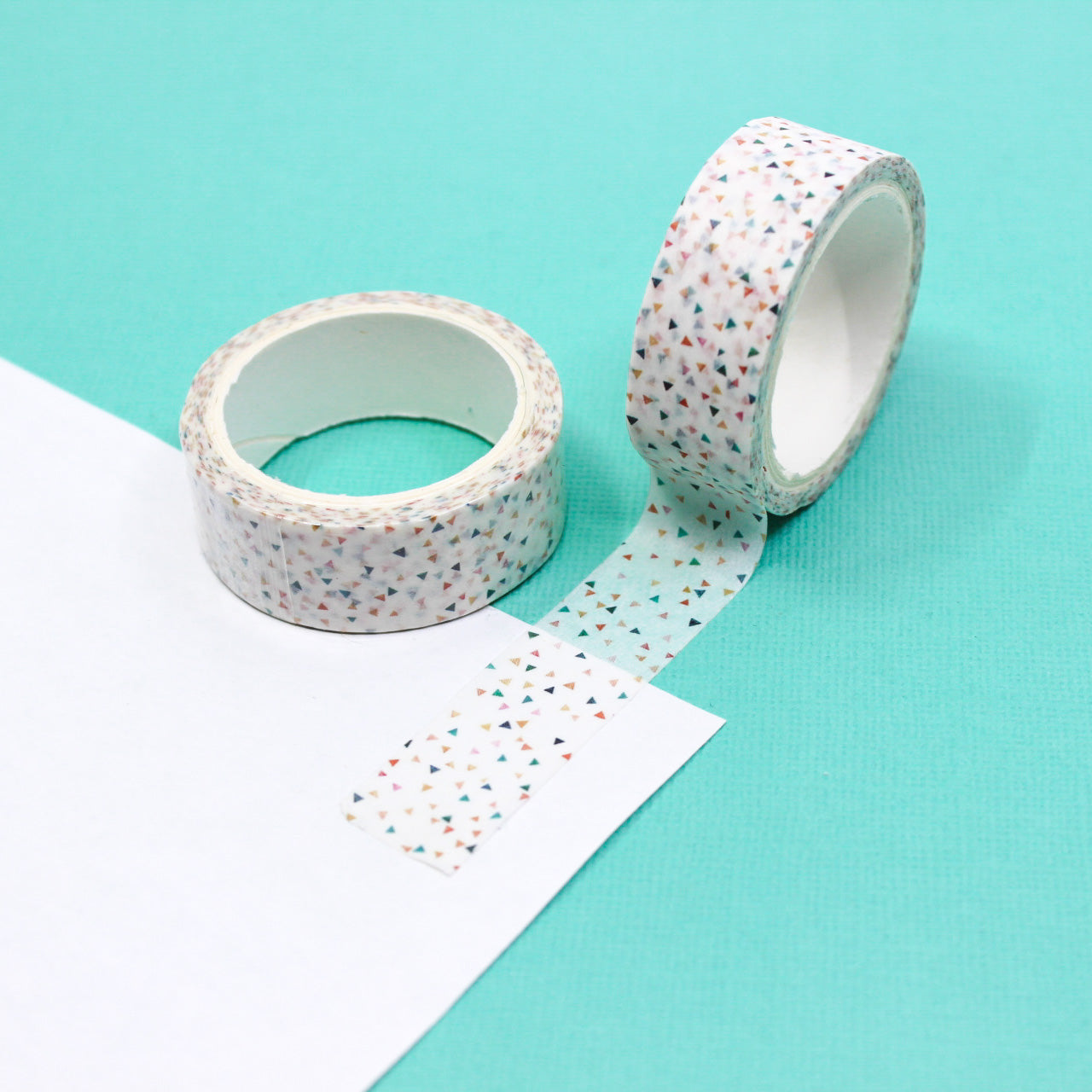 A lively washi tape adorned with colorful triangle confetti patterns, ideal for bringing a playful touch to your planners, scrapbooks, and creative projects. This tape is sold at BBB Supplies Craft Shop!