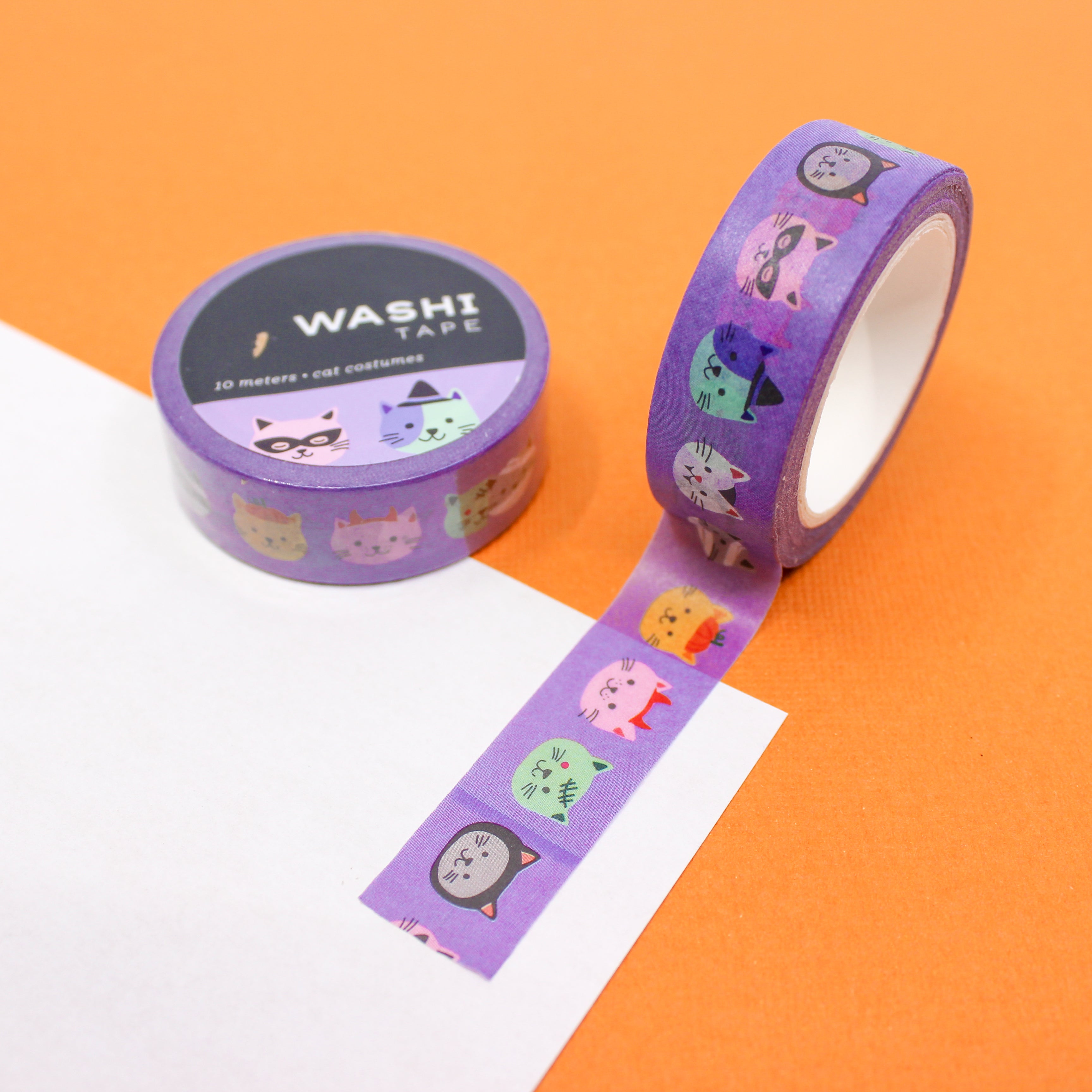 This picture is of purple washi tape with a fun cat costume Halloween theme. The washi tape features Cat faces wearing costumes from BBB Supplies Craft Shop.